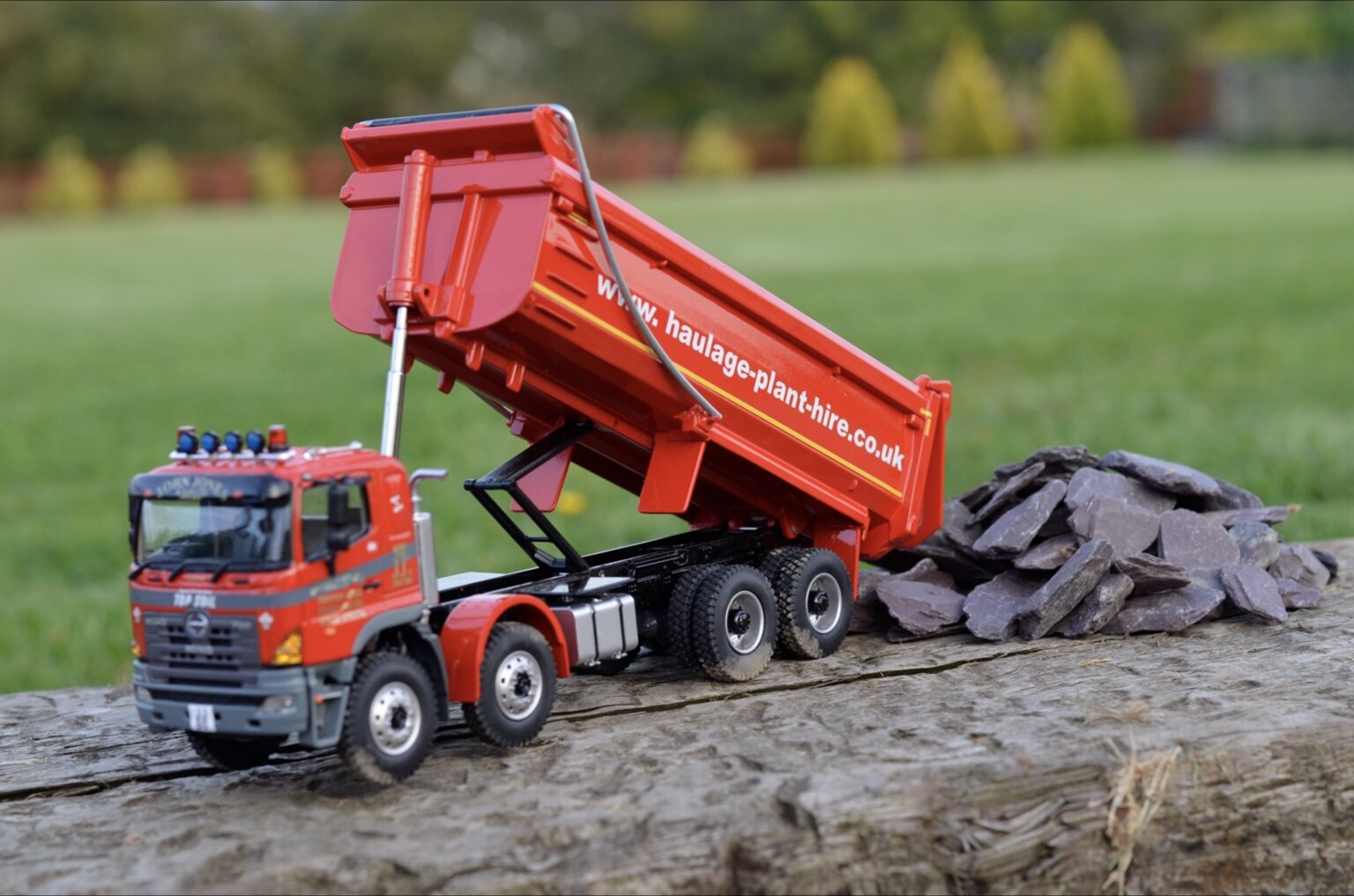 Aggregate delivery tipper model beside slate material
